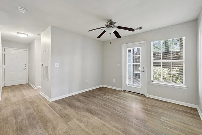 Spacious Living room with hardwood style flooring and a ceiling fan.