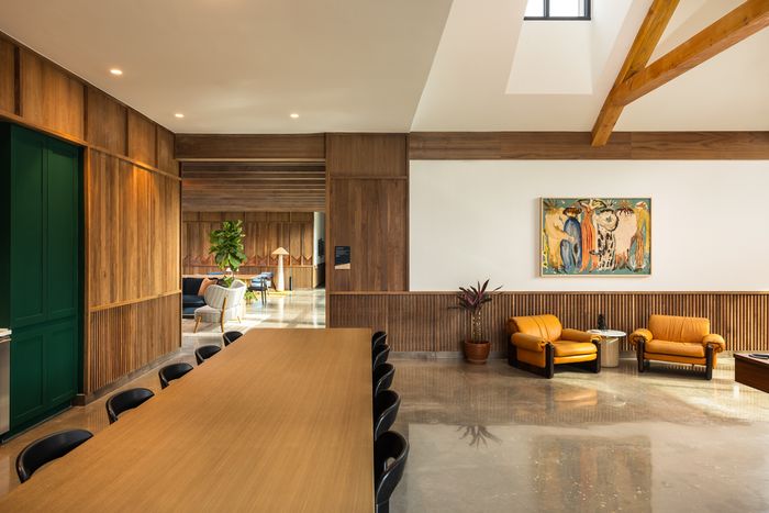Clubroom lounge with leather seating and wood finishes at The Prado apartments in Del Valle, TX