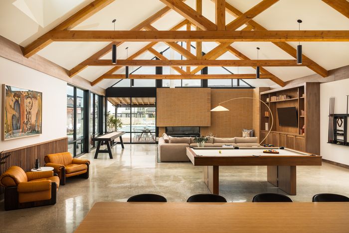 Clubroom with vaulted wood beams and pool table at The Prado apartments in Del Valle, TX