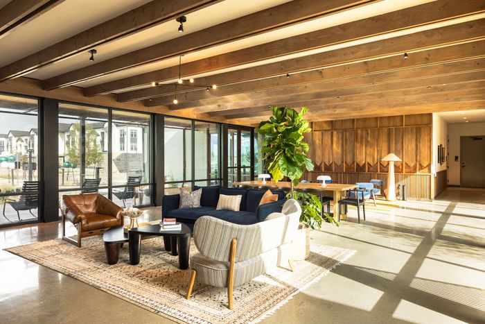 Co-working lounge with soft seating and large windows at The Prado apartments in Del Valle, TX