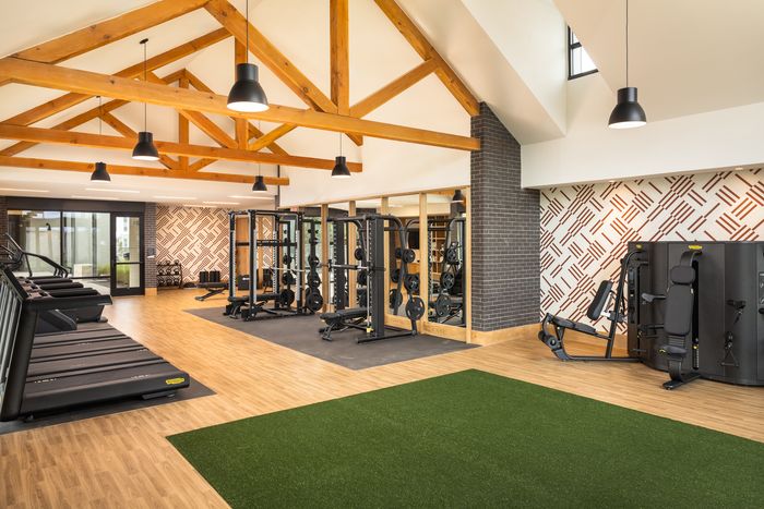 Fitness center with turf zone and strength machines at The Prado apartments in Del Valle, TX