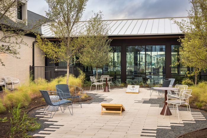 Courtyard with patio seating and landscaping at The Prado apartments in Del Valle, TX