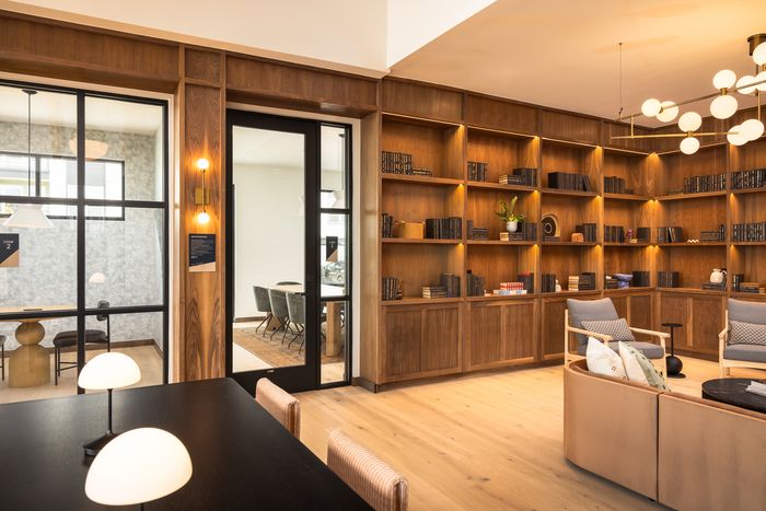 Library with built-in wood shelving and work table at The Prado apartments in Del Valle, TX