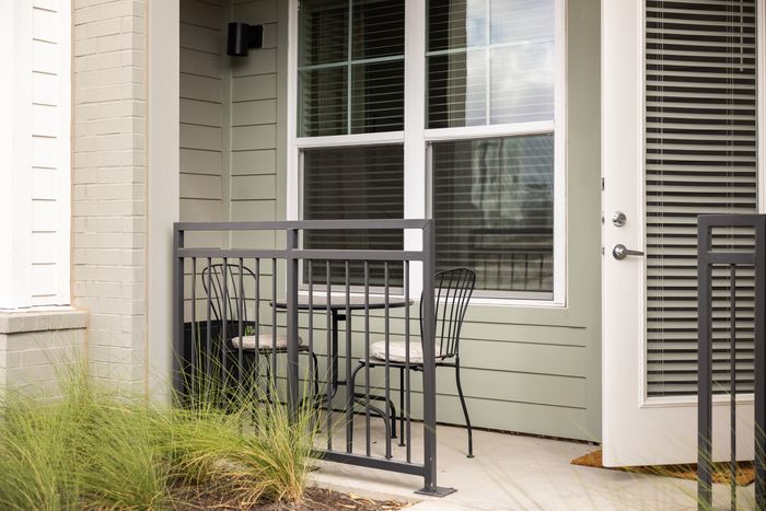 Private apartment patio with bistro seating at The Prado apartments in Del Valle, TX
