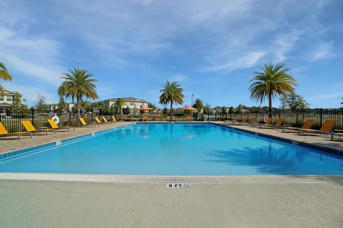 outdoor pool with yellow chaise loungers