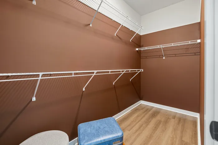 Model residence with large closet, wood plank flooring
