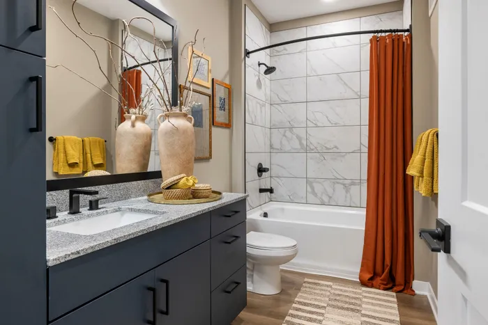Model residence, second bathroom with tiled shower and tub, quartz counters, wood plank flooring