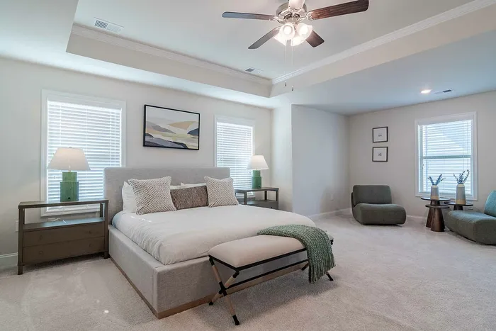 primary bedroom with white bedding and sitting area