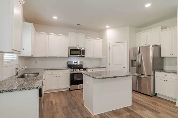 kitchen with white cabinets an island and stainless steel appliances