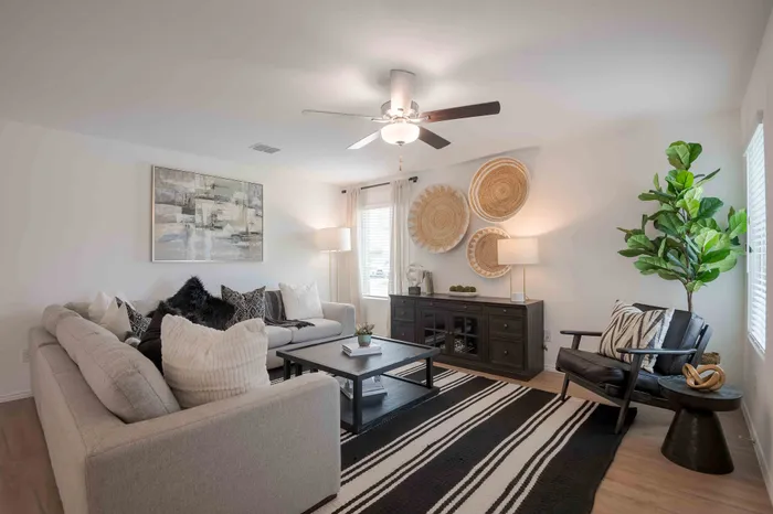 living room with beige couch and striped rug
