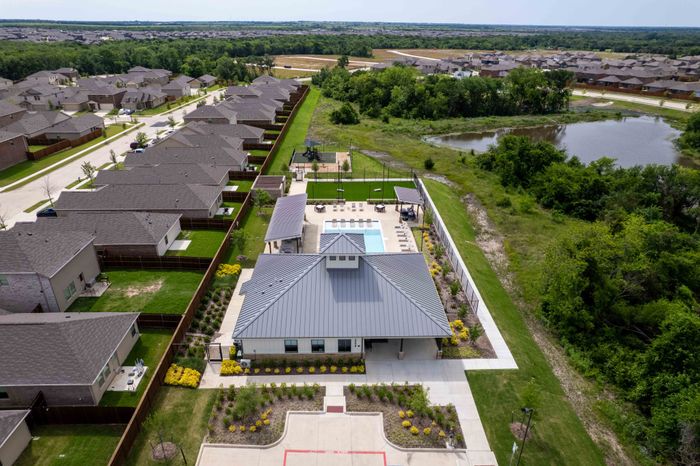 drone photo of clubhouse, pool, community and pond