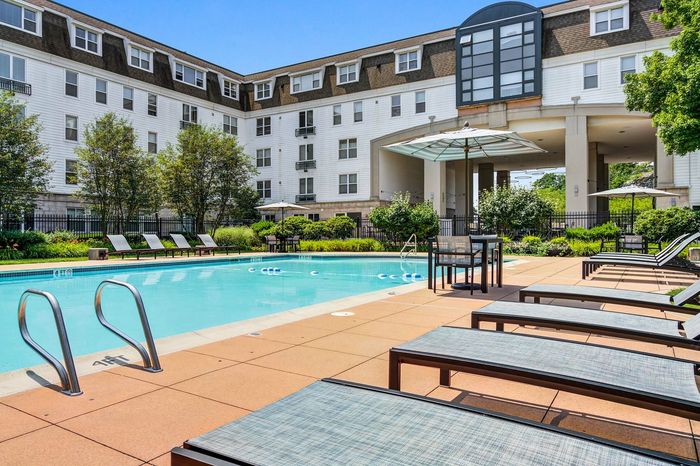 Resort-style swimming pool with sun deck & lounge seating
