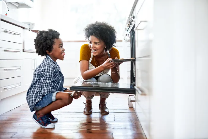 women and child opening an oven