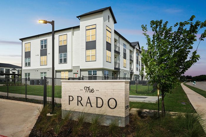 The Prado monument sign with residential building at The Prado apartments in Del Valle, TX