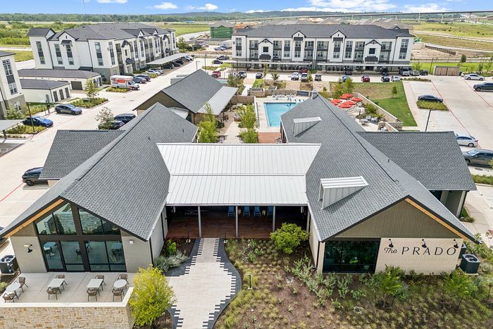 Aerial view of clubhouse and residential buildings at The Prado apartments in Del Valle, TX