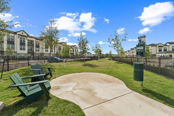 Fenced dog park with seating at The Prado apartments in Del Valle, TX