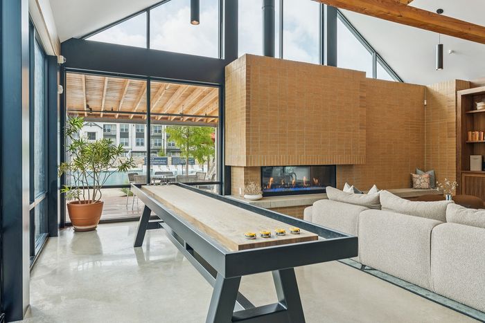 Shuffleboard table in bright resident lounge at The Prado apartments in Del Valle, TX