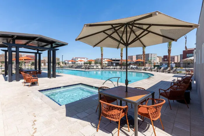 hot tub and pool with lounge areas