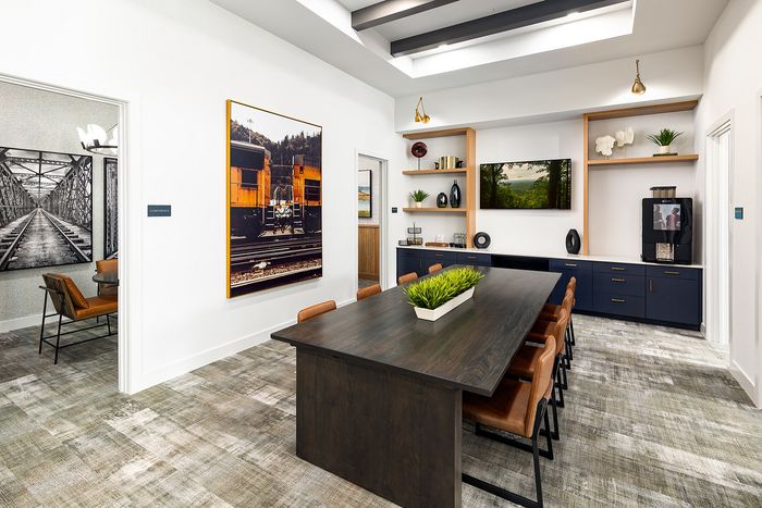 Modern apartment coworking space with dedicated workstations, comfortable seating, and contemporary furnishings.