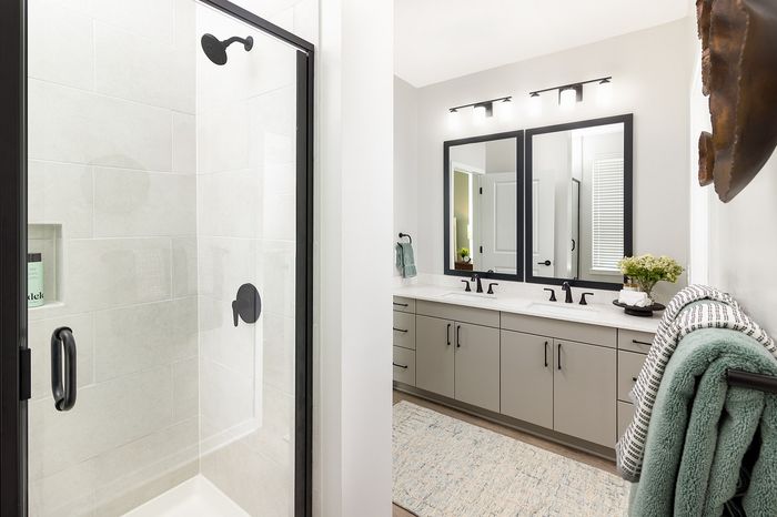 Modern apartment bathroom with glass-enclosed walk-in shower, contemporary vanity, and stylish fixtures.