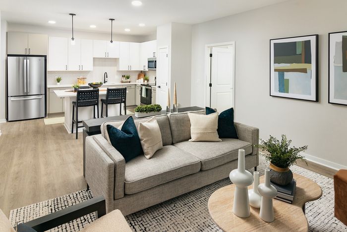 Spacious open-concept apartment living and dining area with modern kitchen, neutral finishes, and natural light.