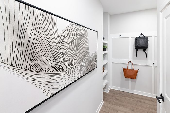 Modern apartment entryway with built-in wall hooks, storage bench, and convenient organization space.