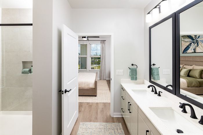 Modern apartment bathroom with glass-enclosed walk-in shower, contemporary vanity, and stylish fixtures.