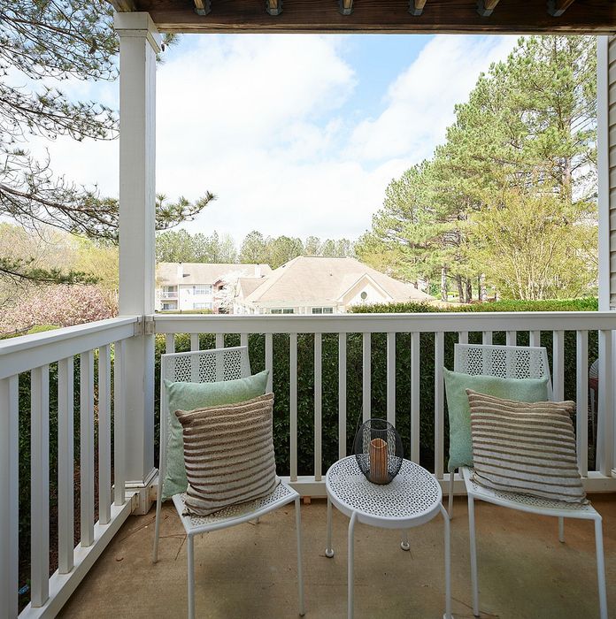 Charming balcony with serene views, featuring cozy seating and lush greenery, perfect for relaxation.