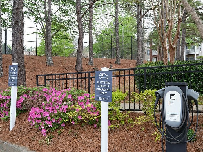 Convenient electric vehicle charging station surrounded by lush greenery and vibrant flowers, enhancing the community's eco-friendly amenities.