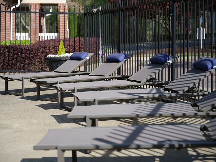 Inviting outdoor area with sleek lounge chairs and plush blue cushions, perfect for relaxing under the sun.