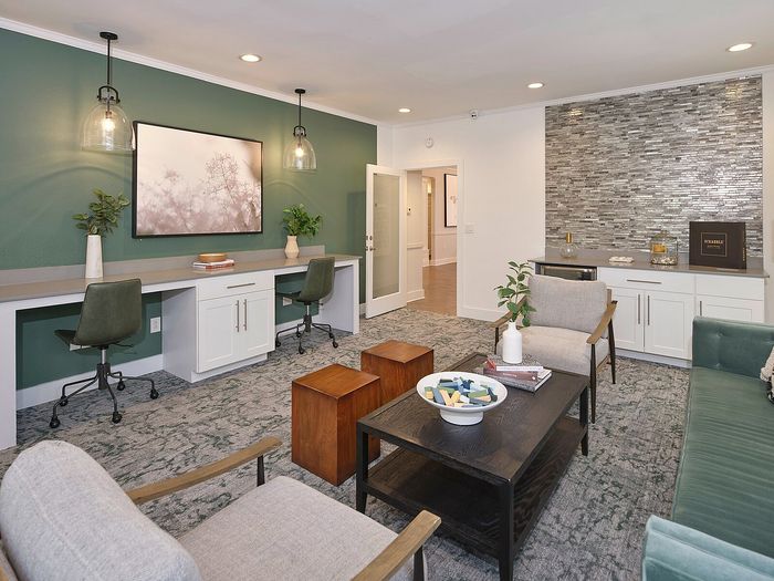 Modern living space with elegant decor, featuring a dual workspace, cozy seating, and stylish wall design perfect for relaxation and productivity.