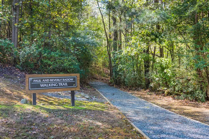 Inviting walking trail entrance surrounded by lush greenery, perfect for nature enthusiasts.