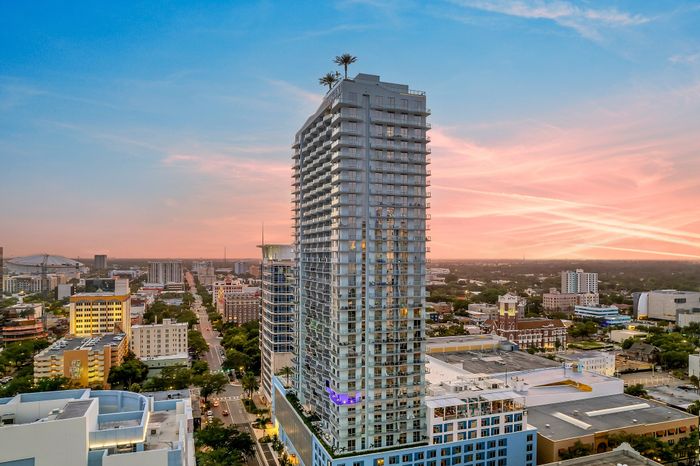 Stunning high-rise building at sunset with cityscape view, showcasing modern architecture and urban living.