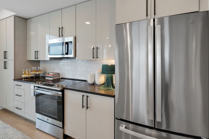 Modern kitchen with sleek stainless steel appliances, glossy cabinetry, and elegant countertops, exuding contemporary sophistication.