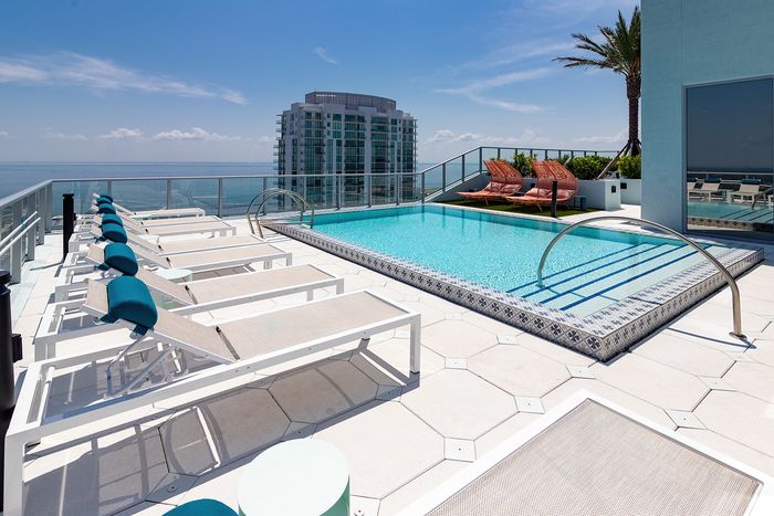 Luxurious rooftop pool with comfortable loungers and stunning ocean views, perfect for relaxation and leisure.