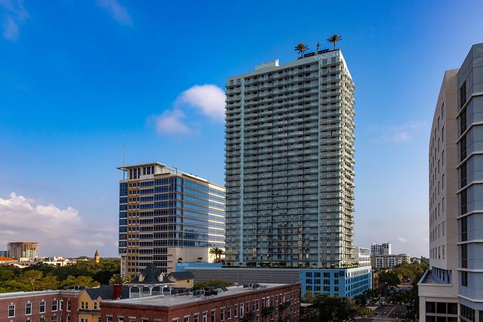 Stunning high-rise building with modern architecture against a clear blue sky, perfect for urban lifestyle seekers.