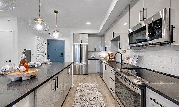 Modern kitchen with sleek cabinetry, stainless steel appliances, stylish lighting, and a spacious island for entertaining.