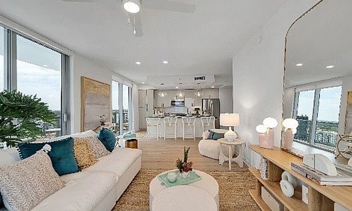 Luxurious open-concept living and dining area with modern decor, abundant natural light, and stunning city views.