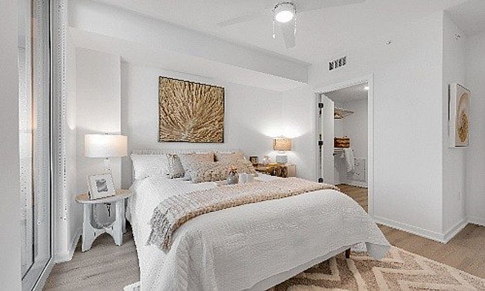 Bright and inviting bedroom with elegant decor, featuring cozy bedding, stylish artwork, and soft lighting in a modern apartment.