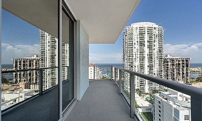Luxurious high-rise balcony with stunning cityscape and ocean views, offering a perfect urban retreat.