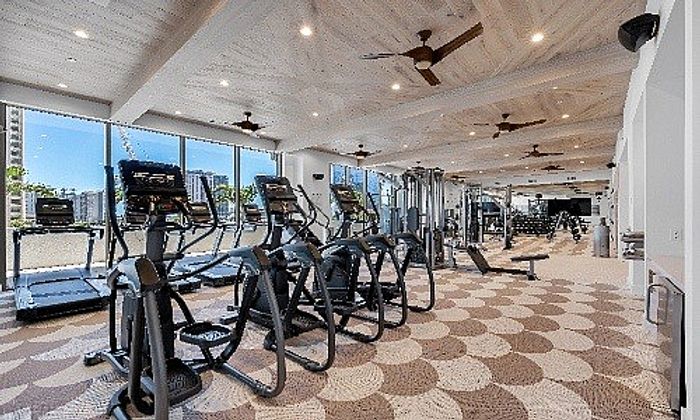 Luxurious fitness center with modern treadmills, elliptical machines, and expansive city views, perfect for a high-end lifestyle.