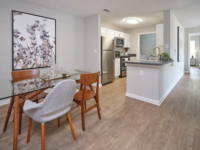 Chic apartment interior featuring a modern kitchen with stainless steel appliances, elegant glass dining table, and stylish decor.