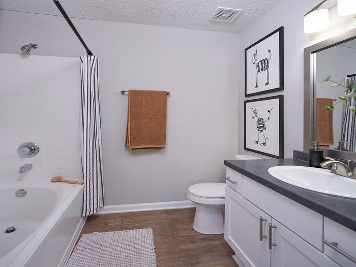 Chic bathroom with modern fixtures, elegant white cabinetry, and artistic wall decor.