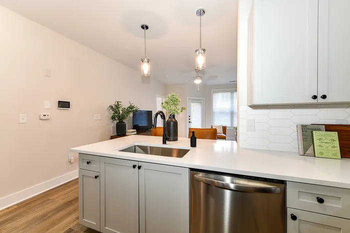 Modern apartment with stylish open kitchen, featuring sleek countertops, elegant fixtures, and inviting living space.