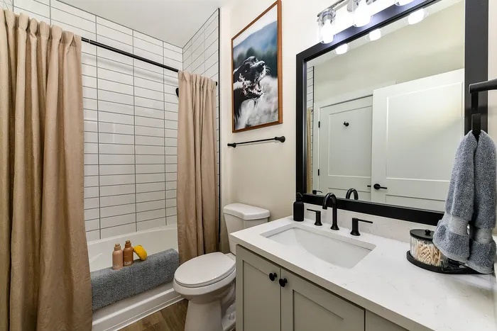 Elegant bathroom featuring modern fixtures, a stylish mirror, and serene decor.