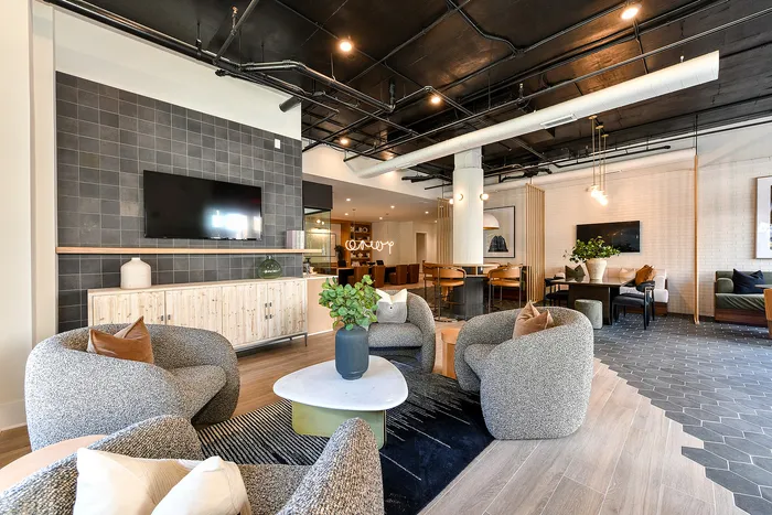 Modern and inviting communal living space featuring stylish seating, sleek tiled flooring, and elegant decor with integrated lighting.