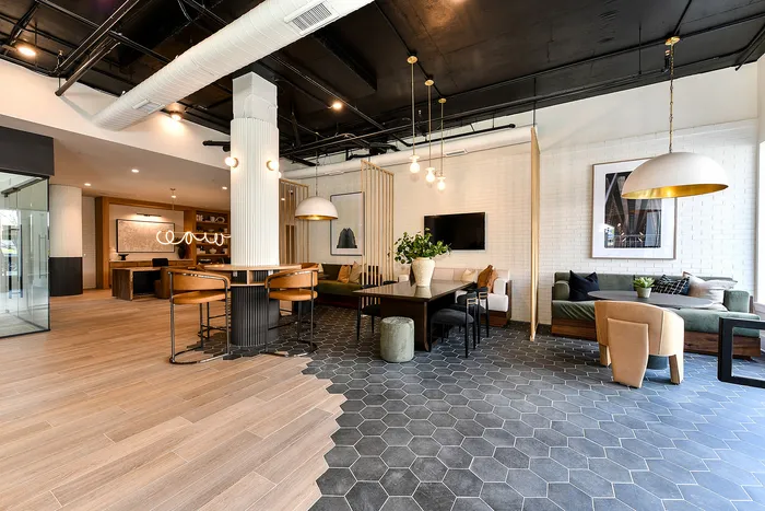 Modern and inviting lounge area showcasing sleek hexagonal tiles, stylish pendant lighting, and comfortable seating for an upscale ambiance.