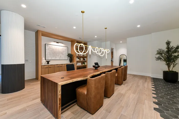 Sophisticated dining area featuring a natural wood table, elegant pendant lighting, and contemporary decor.