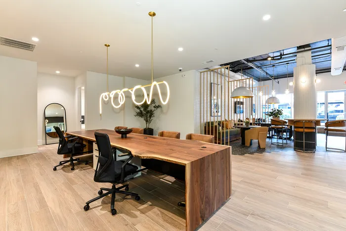 Modern co-working space with sleek wooden tables, stylish lighting, and comfortable seating, perfect for creativity and productivity.
