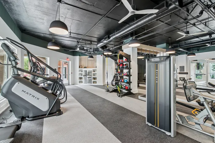 Modern fitness center with state-of-the-art equipment, stylish lighting, and expansive workout space promoting a healthy lifestyle.